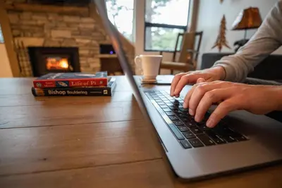 a person typing on a laptop computer on a table at Fantastic 3 Bedroom Condo with Great Views in Mammoth Lakes