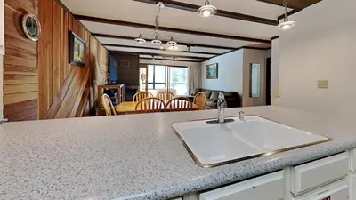 a kitchen counter with a sink and a living room at Amazing 2 Bedroom Condo with Awesome View! in Mammoth Lakes