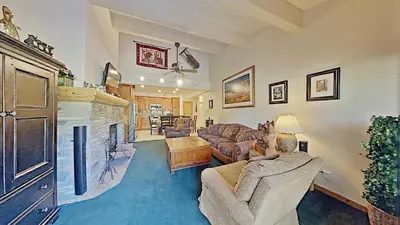 a man sitting in a living room with a fireplace at Spacious Two Bedroom Condo with Loft! in Mammoth Lakes