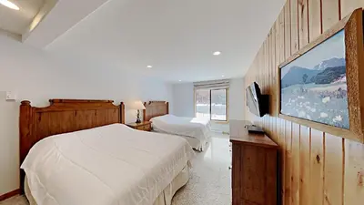 a bedroom with two beds and a flat screen tv at One Bedroom Condo Close To Canyon Lodge! in Mammoth Lakes