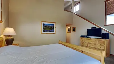 a bedroom with a bed and a tv on a dresser at Beautifully Remodeled 4 Bedroom Home in Mammoth Lakes