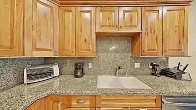 a kitchen counter with a sink and a microwave at Cozy One Bedroom Condo with Loft! in Mammoth Lakes