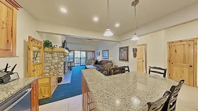 a kitchen and living room with a stone wall at Cozy One Bedroom Condo with Loft! in Mammoth Lakes