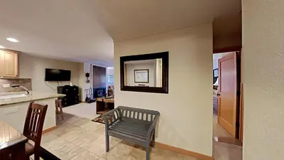 a kitchen and living room with a table and a chair at Spacious One Bedroom Condo with Full Kitchen! in Mammoth Lakes