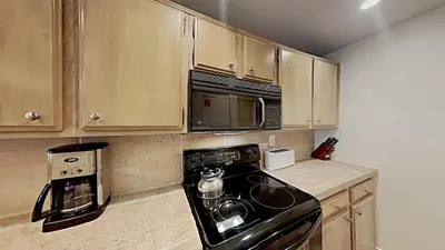 a kitchen with a black stove and a microwave at Updated 2 Bdrm Condo with Shared Hot Tub in Mammoth Lakes