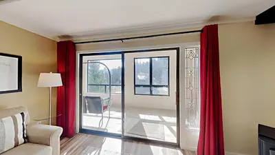 a living room with red curtains and a sliding glass door at Updated 2 Bdrm Condo with Shared Hot Tub in Mammoth Lakes