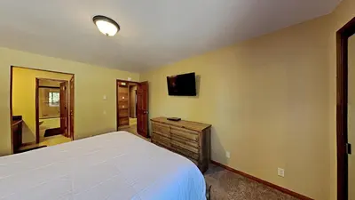a bedroom with a bed and a tv on the wall at Remodeled 2 Bedroom Condo withFull Kitchen! in Mammoth Lakes