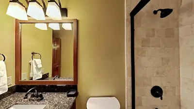 a bathroom with a toilet and a sink and a mirror at Remodeled 2 Bedroom Condo withFull Kitchen! in Mammoth Lakes