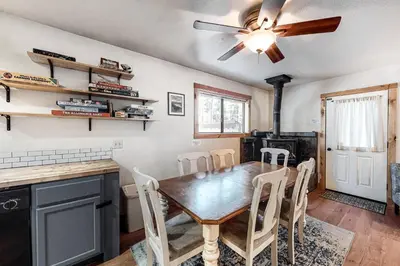 a dining room with a table and chairs and a ceiling fan at Pine Cone Cabin in Soda Springs