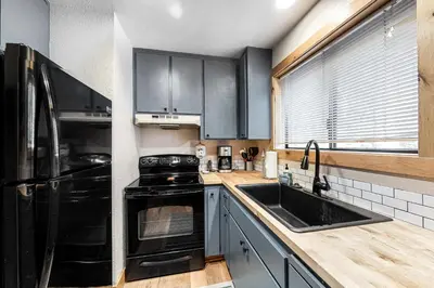 a kitchen with a black refrigerator and a sink at Pine Cone Cabin in Soda Springs