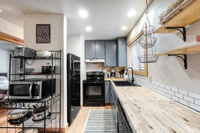 a kitchen with black cabinets and a counter top at Pine Cone Cabin in Soda Springs