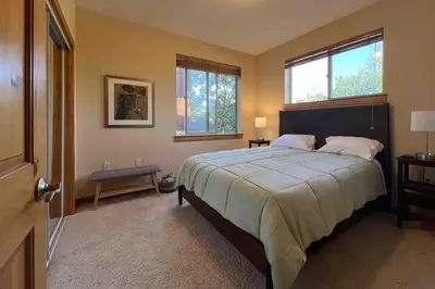 a bedroom with a large bed and two windows at Comfortable and Convenient Truckee Condo in Truckee