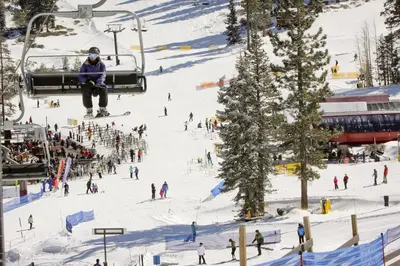 a group of people on a ski lift in the snow at Cozy Condo in Ski Trails in Truckee