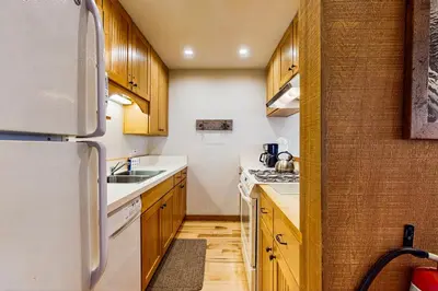 a kitchen with wooden cabinets and a white refrigerator at Cozy Condo in Ski Trails in Truckee