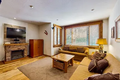 a living room with a couch and a fireplace at Cozy Condo in Ski Trails in Truckee