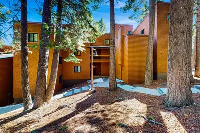 an orange building with trees in front of it at Cozy Condo in Ski Trails in Truckee