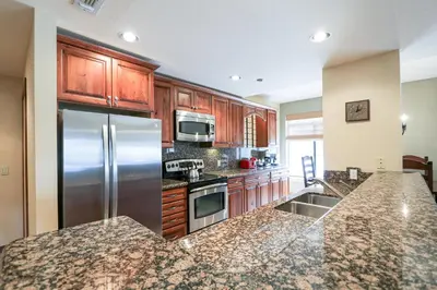 a kitchen with wooden cabinets and stainless steel appliances at Silver Bear #22 condo in Mammoth Lakes
