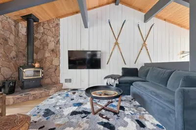 a living room with a blue couch and a fireplace at Villa de los Pinos 42 in Mammoth Lakes