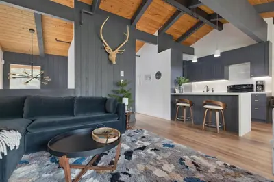 a living room with a couch and a table and a kitchen at Villa de los Pinos 42 in Mammoth Lakes