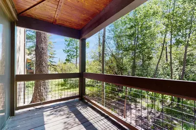 a screened porch with a view of the woods at Delightful Northstar Condo in Kingswood Estates
