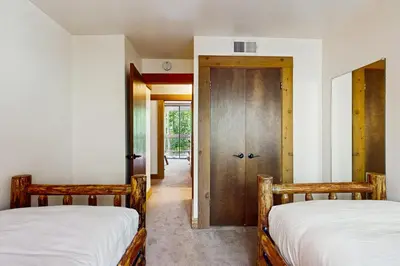 two twin beds in a room with a door at Delightful Northstar Condo in Kingswood Estates