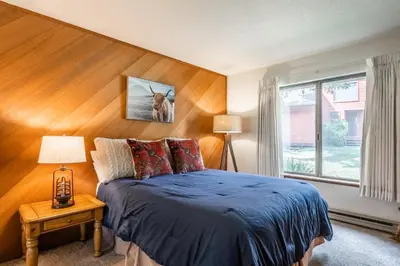 a bedroom with a blue bed and a window at Snowcreek #97 Phase I in Mammoth Lakes