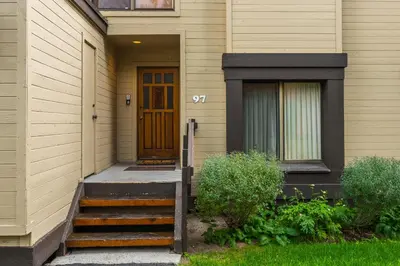a house with a wooden door and stairs in front at Snowcreek #97 Phase I in Mammoth Lakes