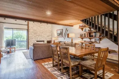 a living room with a wooden table and a couch at Snowcreek #97 Phase I in Mammoth Lakes