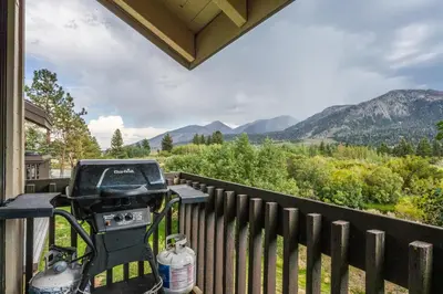 a grill on a porch with a view of mountains at Snowcreek #97 Phase I in Mammoth Lakes