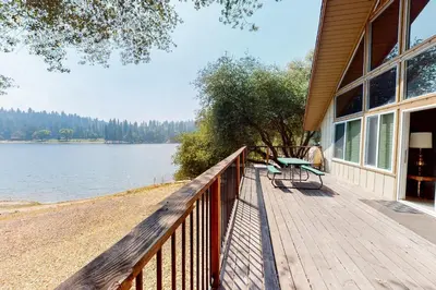 a wooden deck with a bench on the side of a house at Allen Edgewater Retreat in Groveland