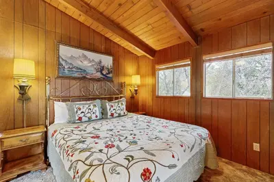a bedroom with a bed with wooden walls and windows at Allen Edgewater Retreat in Groveland