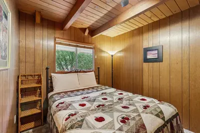a bedroom with a bed in a room with wooden walls at Allen Edgewater Retreat in Groveland