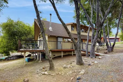a large house with a deck in the woods at Allen Edgewater Retreat in Groveland