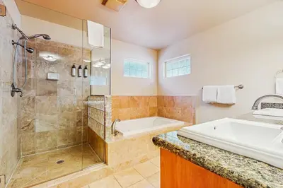 a bathroom with a shower and a tub and a sink at Makoto in Stateline