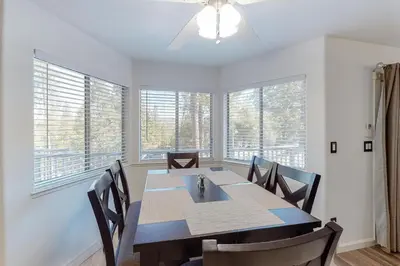 a dining room with a table and chairs and windows at Holiday Chalet in Groveland