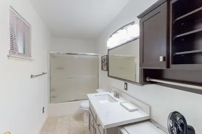 a bathroom with a sink and a toilet and a window at Holiday Chalet in Groveland