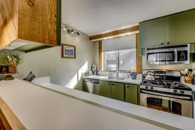 a kitchen with green cabinets and a white counter top at Enjoyable Northstar Condo in Kingswood Estates
