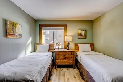 two beds in a room with a dresser and a window at Enjoyable Northstar Condo in Kingswood Estates