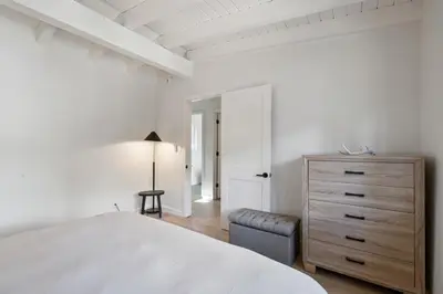 a white bedroom with a bed and a dresser at South Lake Chalet by Heavenly in South Lake Tahoe