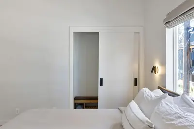 a white bedroom with a bed and a window at South Lake Chalet by Heavenly in South Lake Tahoe