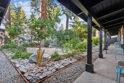 a patio with tables and chairs and trees at South Lake Chalet by Heavenly in South Lake Tahoe