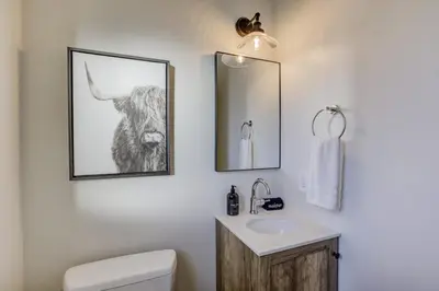 a bathroom with a toilet and a sink with a picture of a bull at South Lake Chalet by Heavenly in South Lake Tahoe