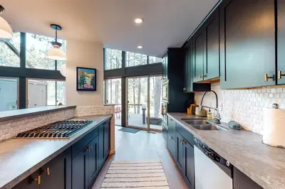 a kitchen with blue cabinets and a sink at Among the Trees in Incline Village