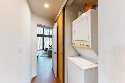 a kitchen with a white refrigerator and a living room at Among the Trees in Incline Village