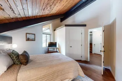 a bedroom with a large bed with a wooden ceiling at Among the Trees in Incline Village