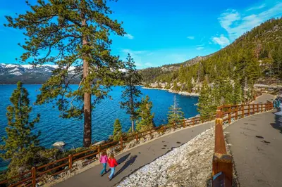 two people walking along the shore of a lake at Among the Trees in Incline Village