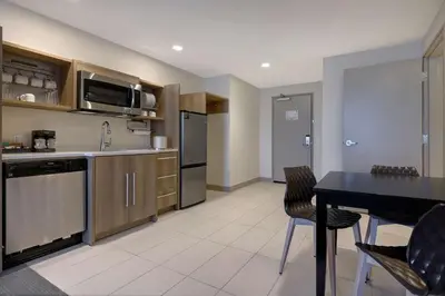 a kitchen with a black table and chairs in a room at Home2 Suites By Hilton Turlock, Ca in Turlock