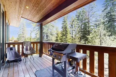 a grill on a deck with a view of the woods at Truckee Treat in Truckee