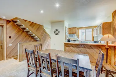 a kitchen with a dining room table and a staircase at Cheery Gold Bend Family Condo in Truckee