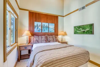 a bedroom with a bed with two lamps and two windows at Cheery Gold Bend Family Condo in Truckee